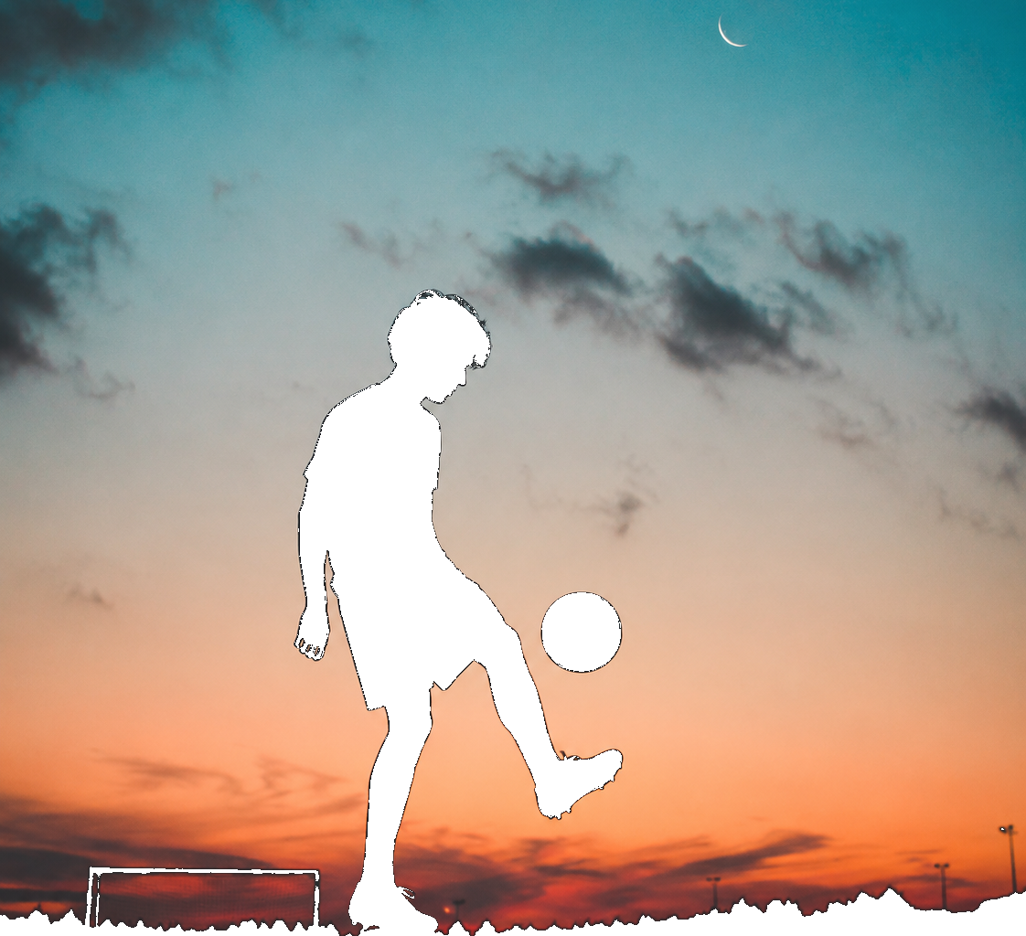 Person silhouetted against a colorful sunset sky while juggling a soccer ball after color removal
